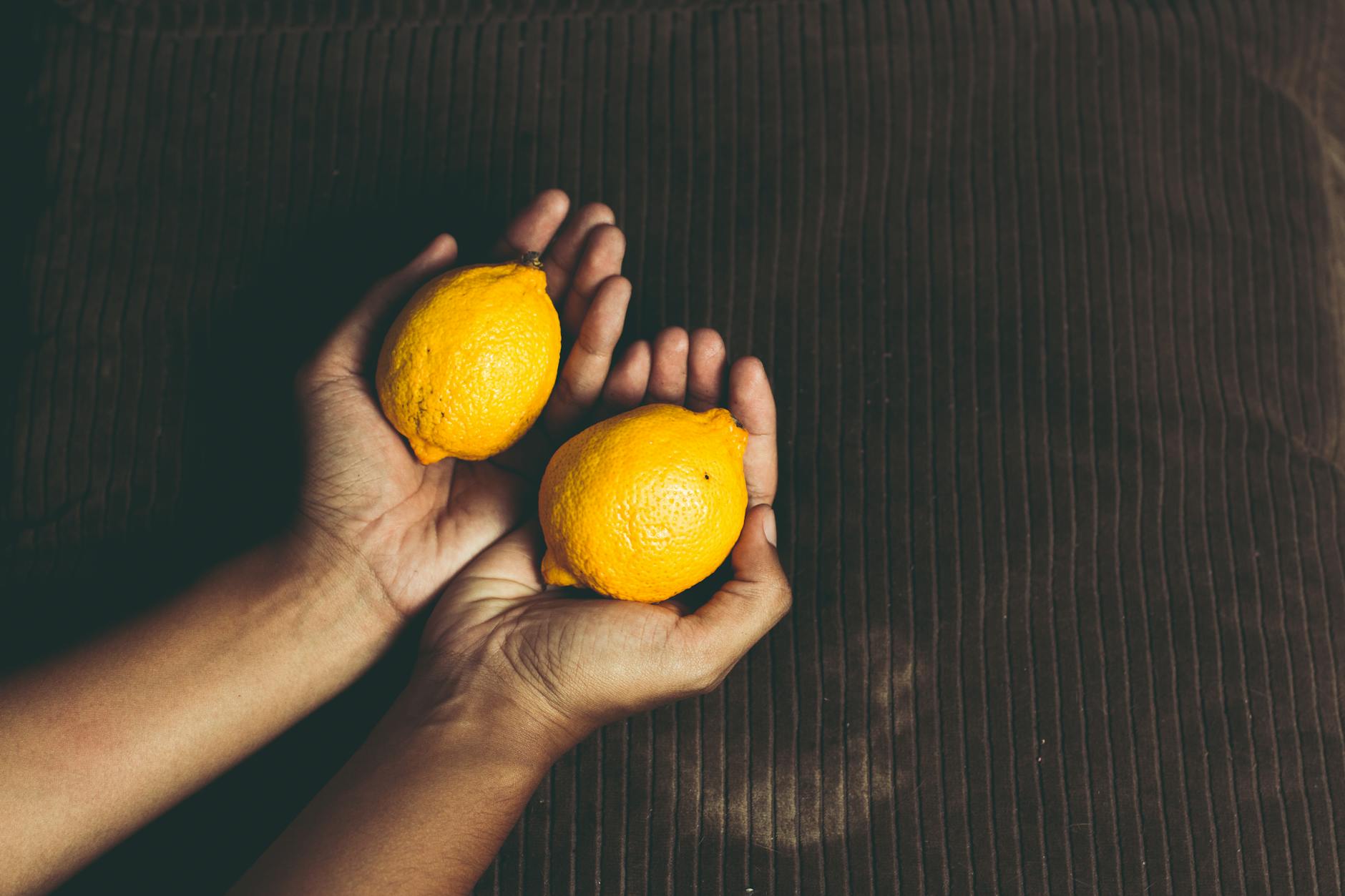 Citrons frais jaunes empilés avec des livres sur une surface blanche, symbole de patience et de découverte