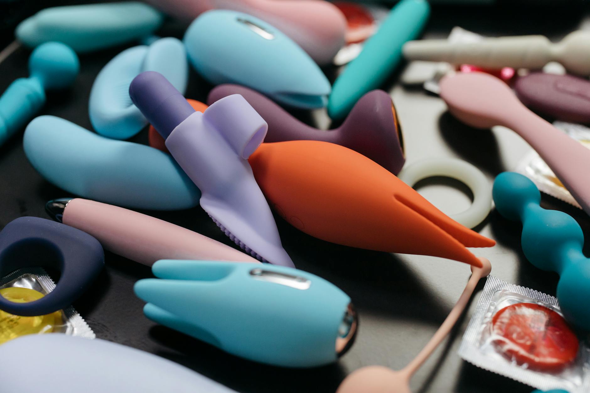 Femme tenant deux vibromasseurs colorés dans un moment de contemplation et d'exploration personnelle