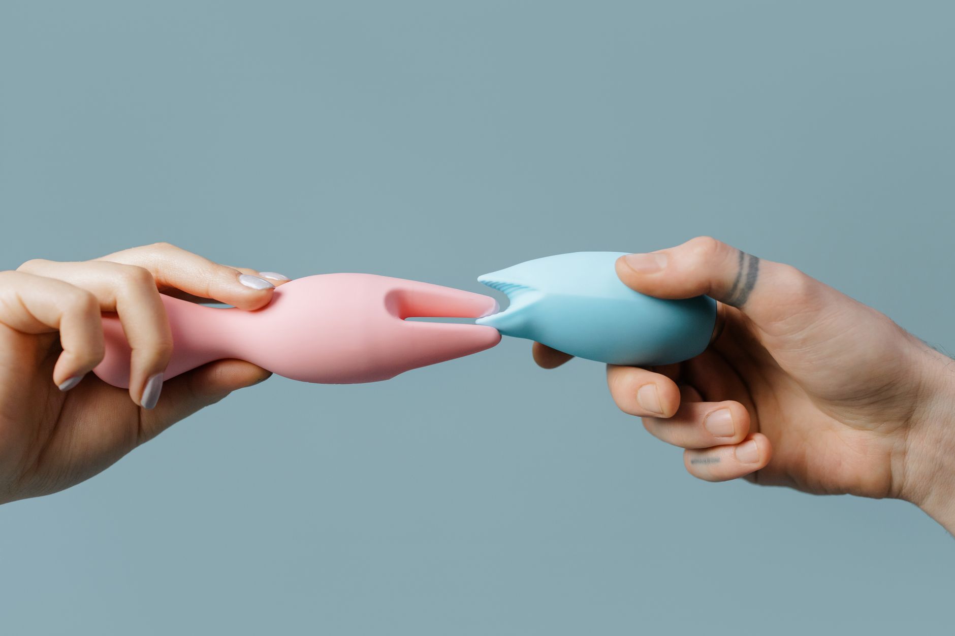 Gros plan des mains tenant un vibromasseur citron bleu contre un fond violet