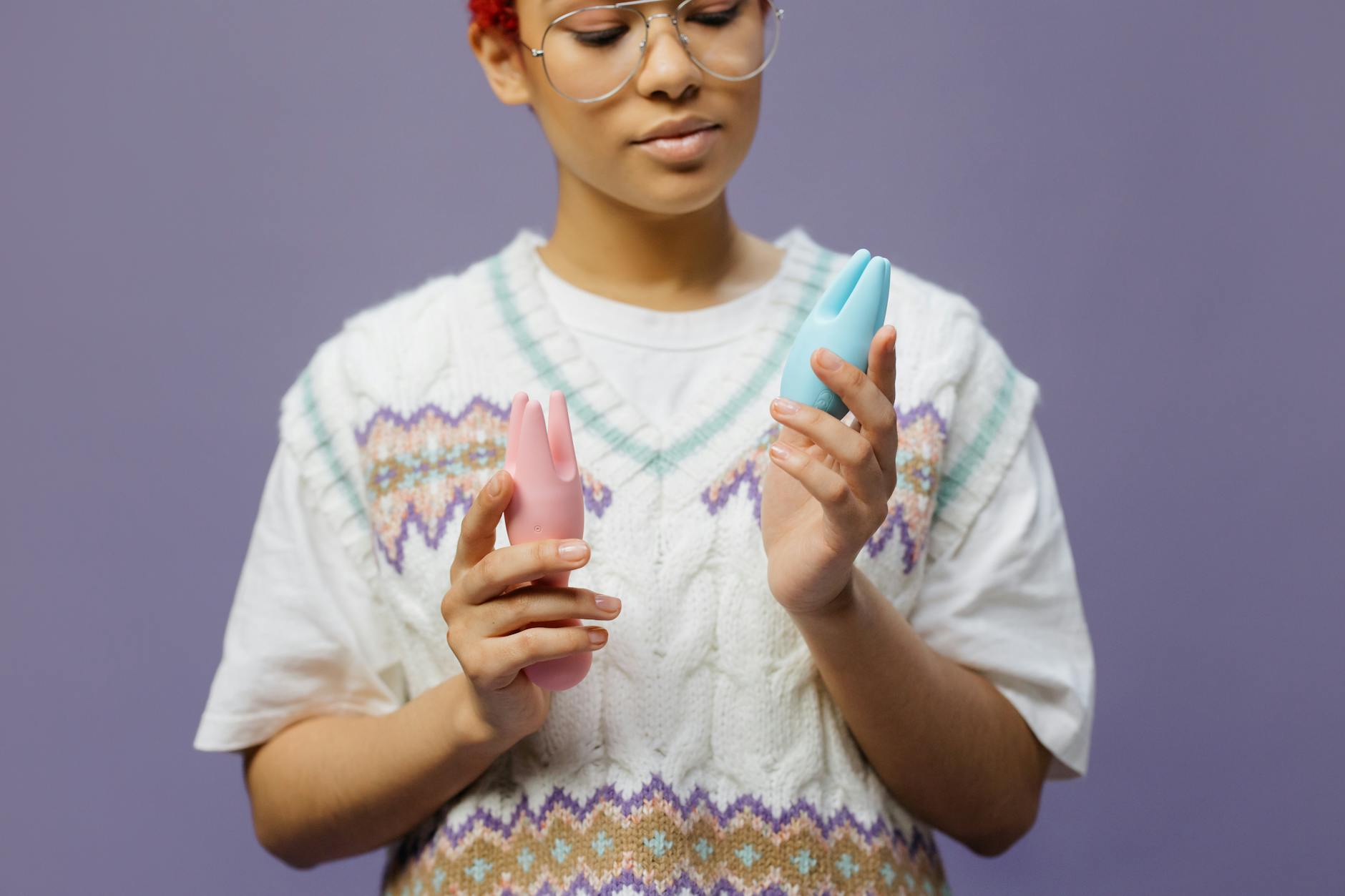 Femme tenant un vibromasseur bleu et rose en silicone, explorant les jouets sexuels modernes