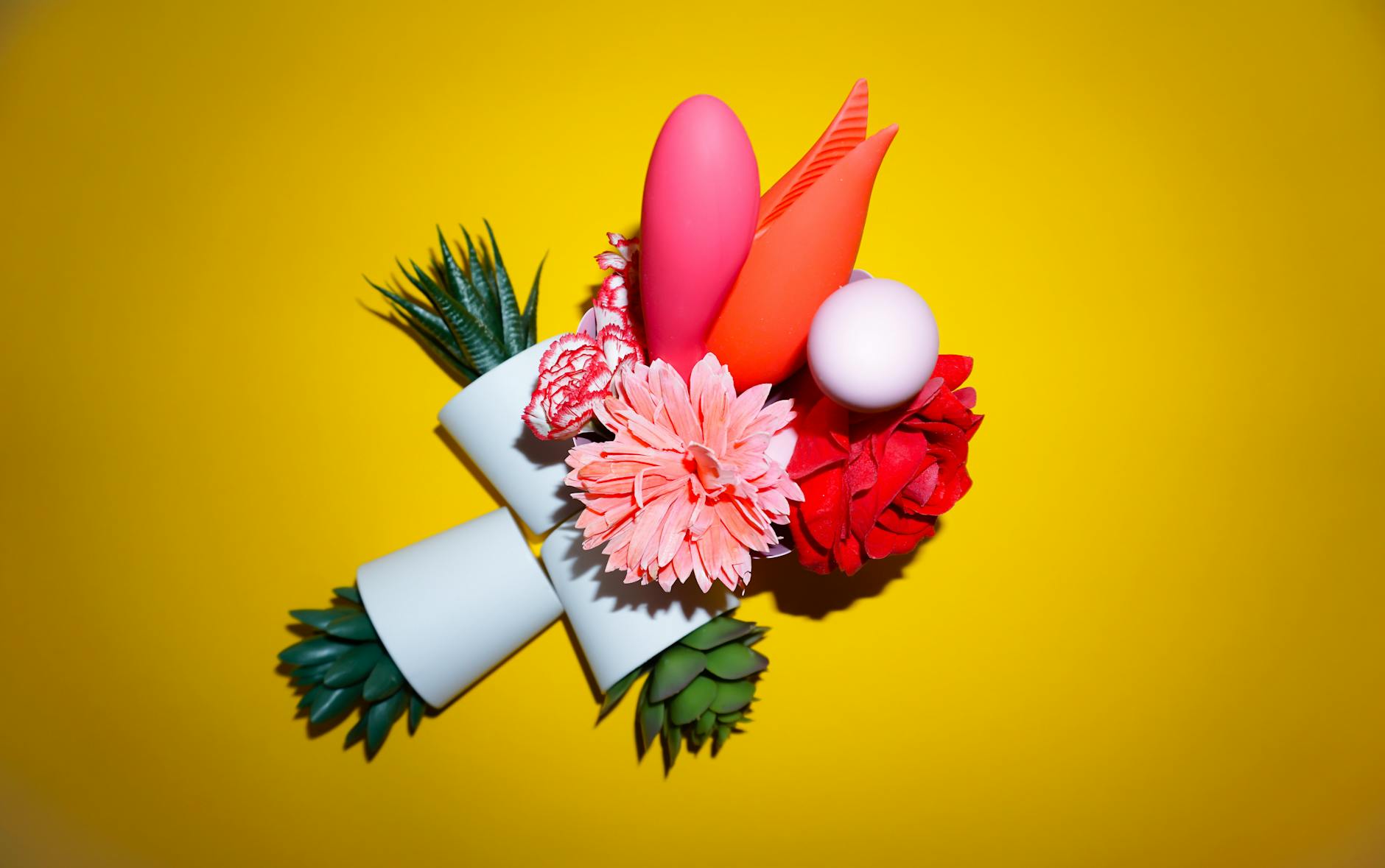 Vibrant collection of colorful sex toys on a bright yellow background